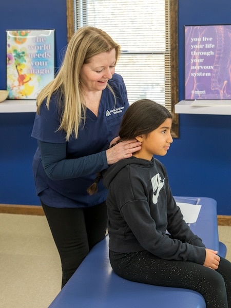 A girl being adjust by Annie Jackman chiropractor